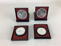 Overview of four coins in original cases