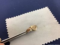 Photo of the 10K gold ring viewed from an angle showing the front 'EZ' engraving and the band profile.