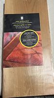 Top-down image of a rectangular cedar grilling plank with label describing it as great for seafood, meats and vegetables, including recipe and instructions.