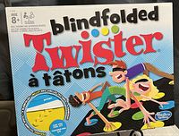 Photo of the Blindfolded Twister game box showing branding, illustrations, and game type.