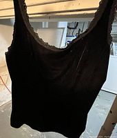 Photo of a black ladies camisole in size large, showing lace trim detail around neckline and armholes.