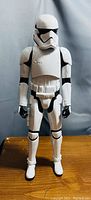 Front view of the Star Wars First Order Stormtrooper action figure on a wooden surface, showing full body and armor details.