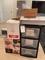 Whole storage unit and surrounding boxes in living room setting.