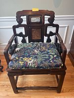 Front view of the carved wood chair with decorative cushion and back insets