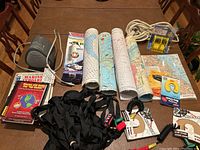 Wide shot showing an assortment of boating maps, tie down straps, a fire extinguisher, retrieval magnet, coiled rope, and boating accessories