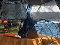 Four twin air mattresses spread and folded on a surface with their box showing.