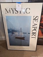Framed Mystic Seaport poster with black frame showing boats docked in harbor and text about Mystic, Connecticut maritime heritage.
