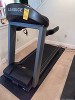 Side angle of the Landice treadmill on the floor mat.