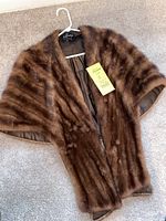 Full view of vintage brown mink stole hanging on a hanger, showing the warm brown fur and full lining.