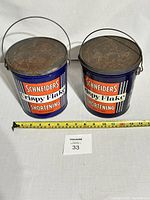 Two Schneiders Crispy Flake Shortening tins side by side with a measuring tape
