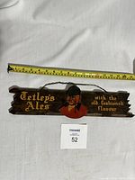 Full view of Tetley's Ales wooden pub sign with chain, including measurement tape showing length around 17 inches