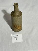 Full view of the tall cylindrical stoneware bottle with some brown discoloration and aged surface.