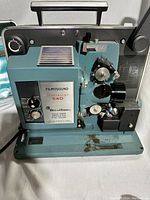 Front and left side view of Bell & Howell Filmosound Specialist 540 16mm sound projector showing motor, film threading mechanism, and control knobs.