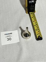 Small silver onion-shaped candle stick holder next to measuring tape showing the height is about 2.5 inches.