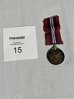 Full view of World War II military medal with attached ribbon showing overall condition and size.