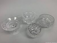 Overview of all four Waterford crystal pieces including candy dishes and bowls on white surface.