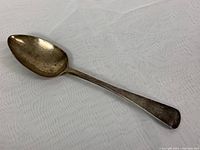 Full view of the sterling silver serving spoon, showing its overall shape and length.