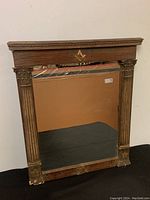 Front full view of the 18th Century Masonic wall mirror with wooden frame and Masonic symbol at top center.