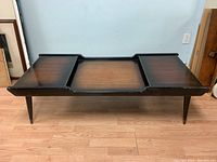 Front and top view showing three segmented wood surfaces and tapered legs.