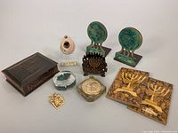 Overview photo showing all items in the lot including bookends, napkin holders, trinket box, paperweights, and pendant.