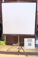 Front view of the Kodak movie projection screen fully extended on tripod stand showing 40x40 inch white projection surface with brown border.