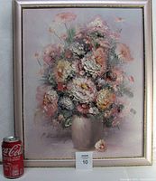 Frontal view of framed oil painting with floral bouquet showing overall condition and size comparison with a soda can.