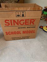 Cardboard box for Singer School Model sewing machine showing branding and intended use for classroom.