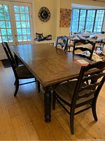 Dining table with four chairs around it, table top and chairs visible showing surface wear and upholstery seat color