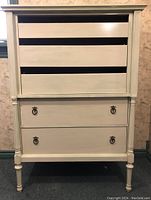 Front view of the tallboy dresser showing two lower drawers with metal ring pulls and two upper drawers missing drawer fronts.