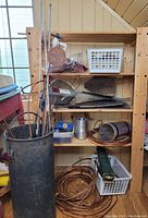 Overview of wooden shelf with multiple copper and metal crafting materials including coils, rods, metal sheets, and a metal tumbler.