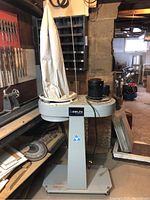 Front view of Delta ShopMaster dust collector with pedestal, dust bag, and motor assembly