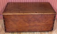 Front view of the pine blanket box showing dovetail joints and medium brown finish.