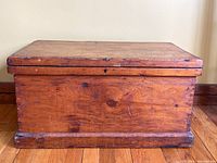 Front view of the pine chest showing aged wood surface and solid base molding.