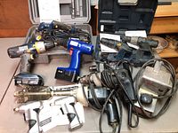 Full lot of nine power tools including cordless drills, planer, sander, and screwdrivers with cords and cases.