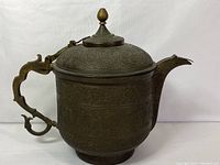 Full side view showing overall shape, handle, spout, and engraving coverage