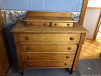 Front view of vintage wood dresser showing four large drawers and two small top drawers with wooden knobs.