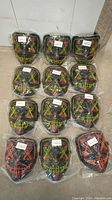 Photo showing 12 individually sealed LED glowing masks in various colors including yellow, red, and green stitches on black masks.