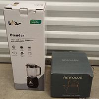 Box of Bear brand blender and box of Amfocus stovetop tea kettle side by side