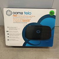 Front of sealed Ooma Telo box showing product name, branding, and key features.