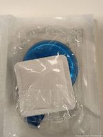 Close-up of a single Stericup disposable spoon sealed in factory packaging, blue color