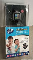 Original packaging of Vtech Kidi Zoom Smart Watch DX3 showing front and side views with product information and images of children wearing the watch.