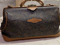 Front view of the Texier men's leather bag showing patterned canvas and leather trim with logo patch.