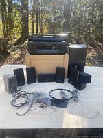 Sony STR-AV2075 audio/video control center, Panasonic DVD player, LG surround sound speakers including subwoofer and satellite speakers, assorted wires on table outside.