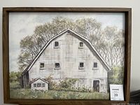 Framed painting of a white rustic barn with surrounding bushes and trees