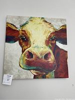 Close-up photo of square 20x20 canvas wall art with a colorful cow portrait.