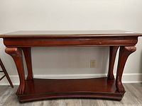 Front view of solid wood console table showing carved legs and rectangular top.