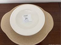 Top view of one white bowl placed on a light brown platter showing size and color contrast.