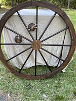 Decorative wooden wagon wheel with 8 spokes against outdoor background, no packaging