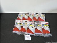 Ten packs of Arrow glue sticks arranged on black surface, all unopened and factory sealed.