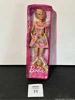 Front view of Barbie 181 in pink zippered case showing floral dress and sunglasses, in original packaging.